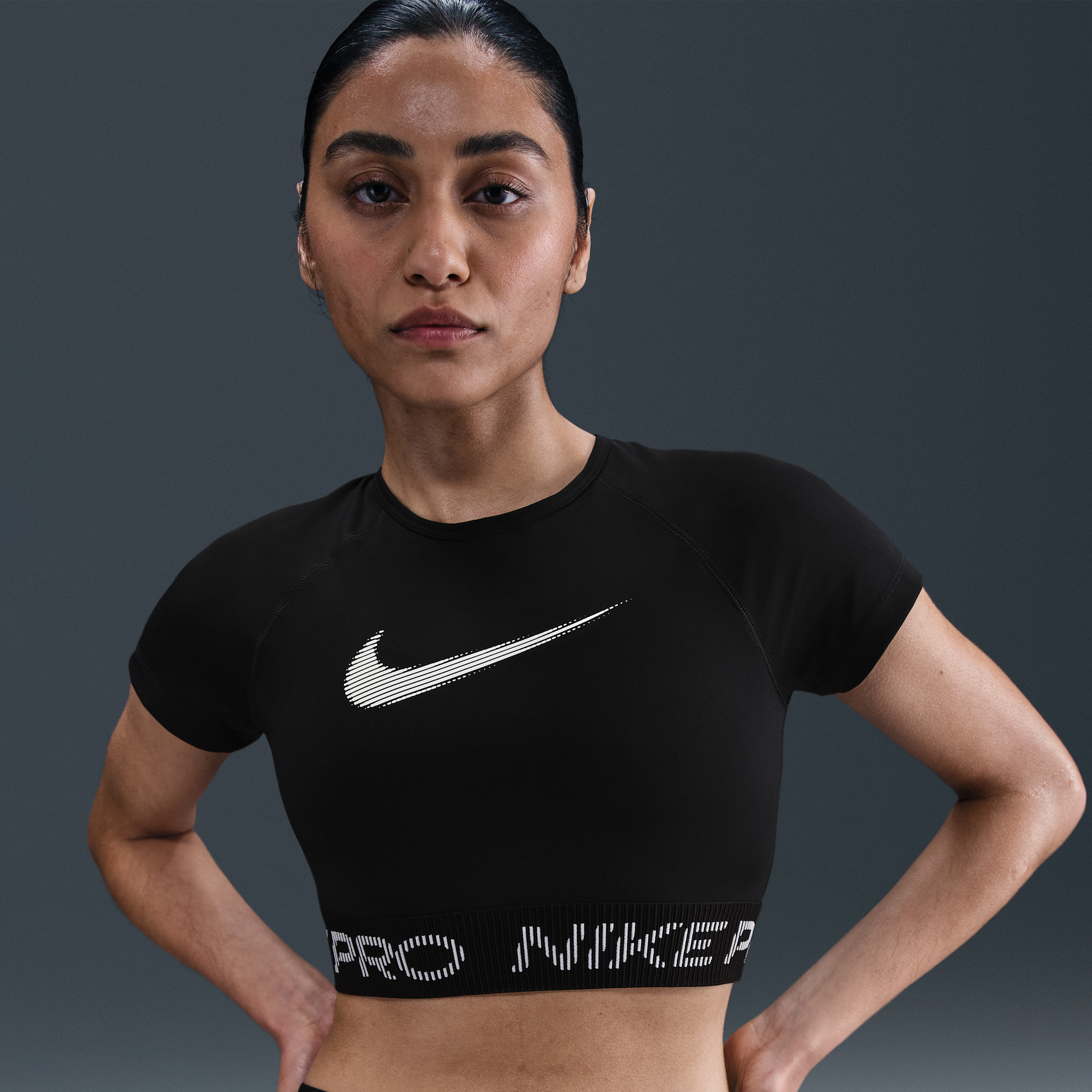 Thumbnail - Nike Pro Dri-FIT kürzer geschnittenes Kurzarmshirt mit Grafik (Damen) - Schwarz