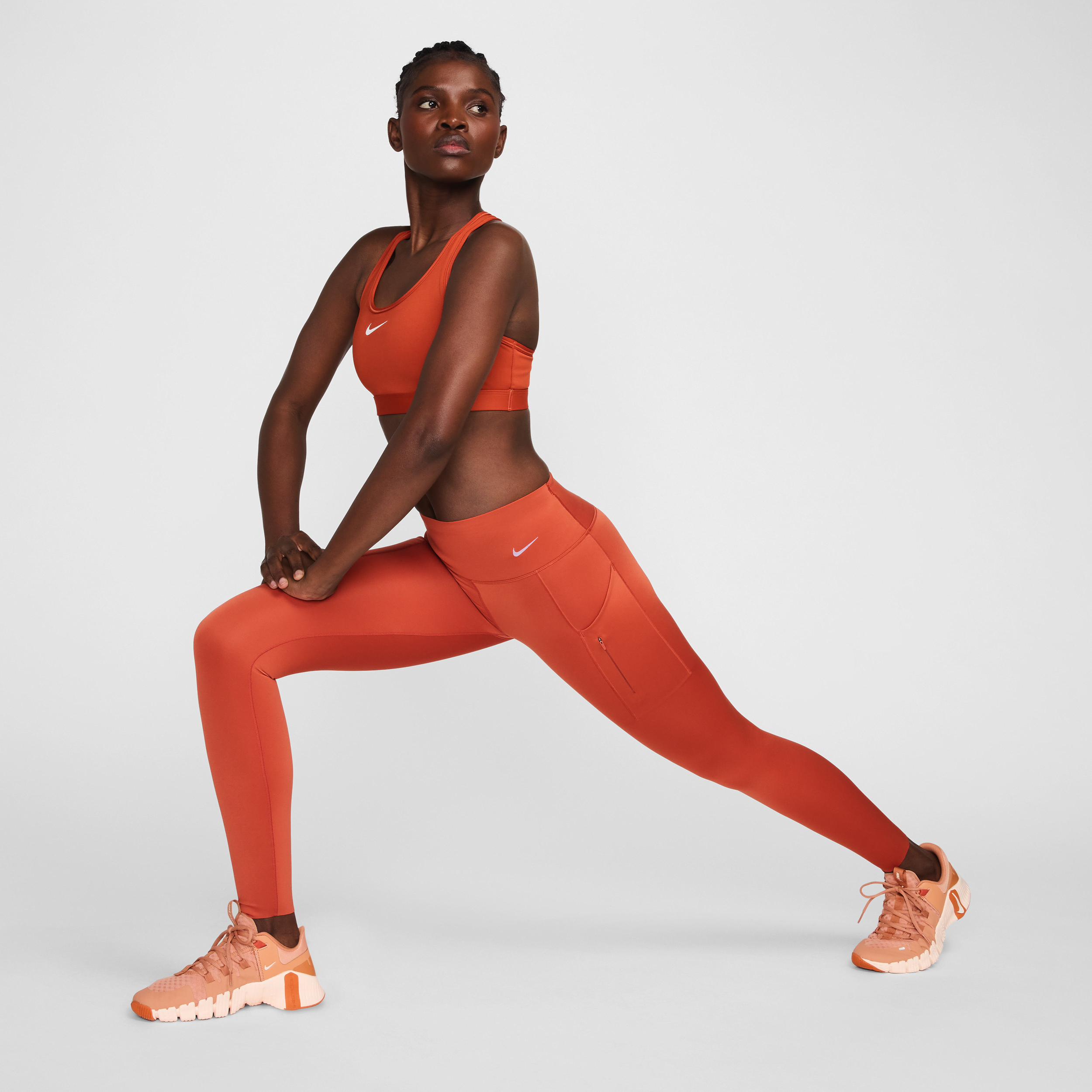 Lange Nike Go-leggings med højt støtteniveau, mellemhøj talje og lommer til kvinder - Orange
