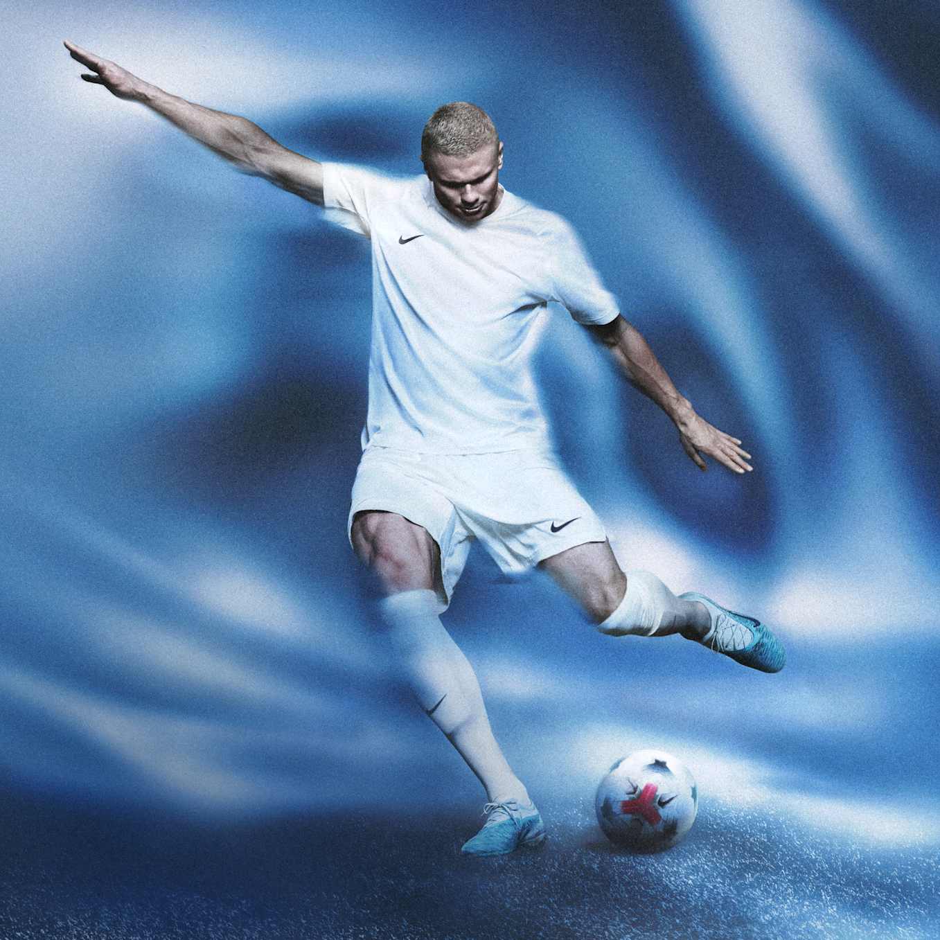 Erling Haaland kicking a football against a blue background next to a floating blue Nike Phantom 6 Elite boot, wearing a white kit., Impossible to Contain