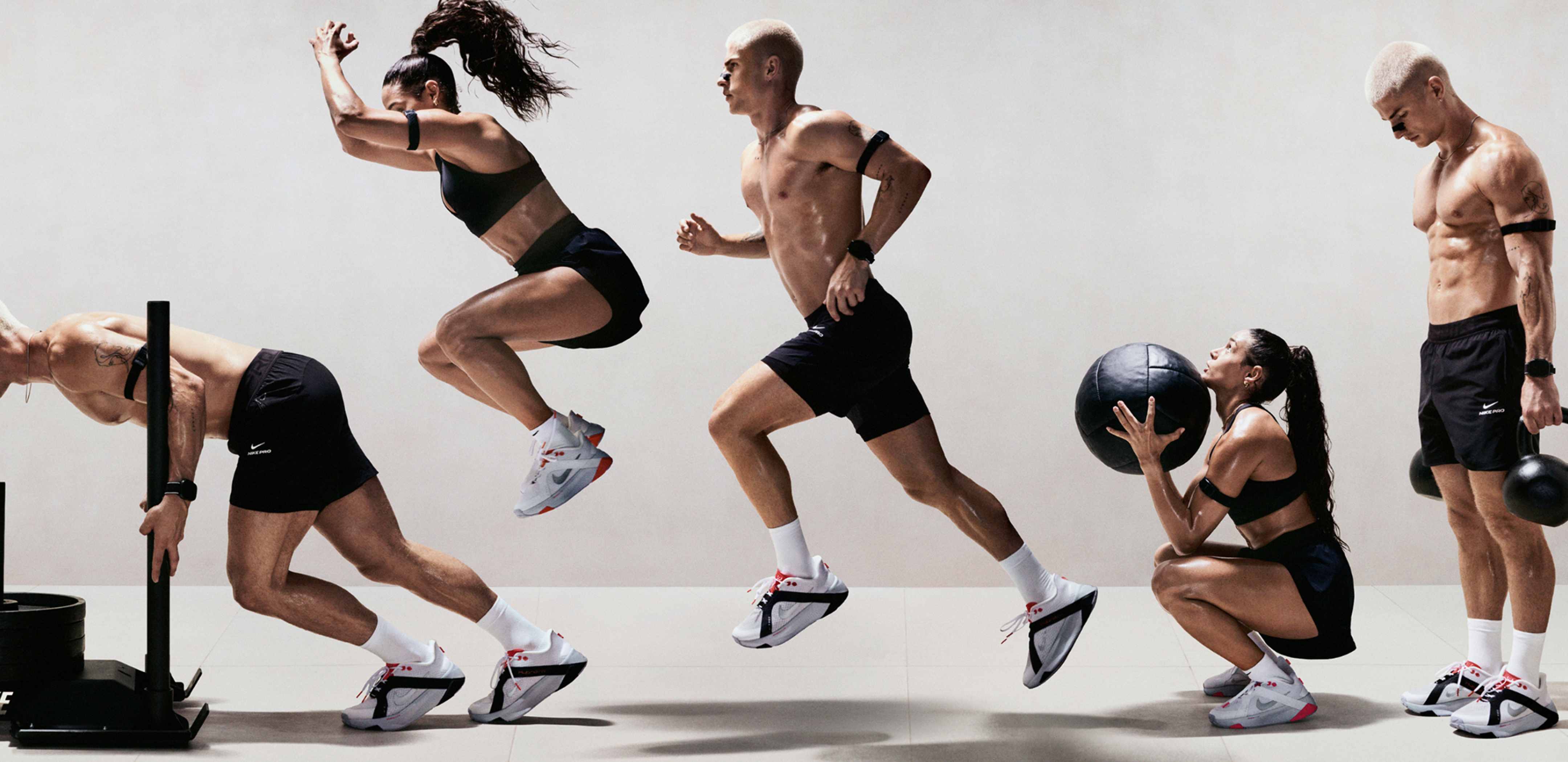 En mann og en kvinne utfører forskjellige styrke- og kondisjonsøvelser i et lyst studiolokale. De har på seg svart treningsantrekk og Nike Hybrid RN-treningssko., HVORFOR VELGE?
