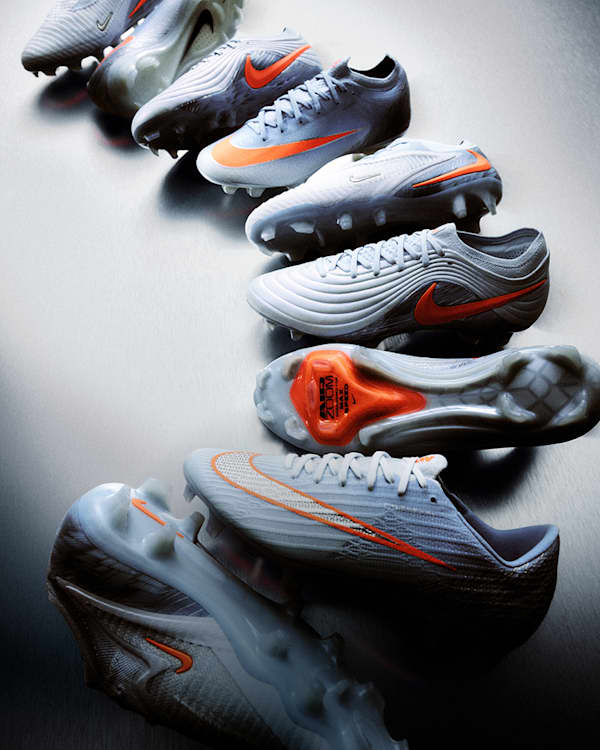 Trending Now, Image showing multiple light blue Nike United football boots with orange detailing arranged across a metallic grey surface., slide 2 of 5