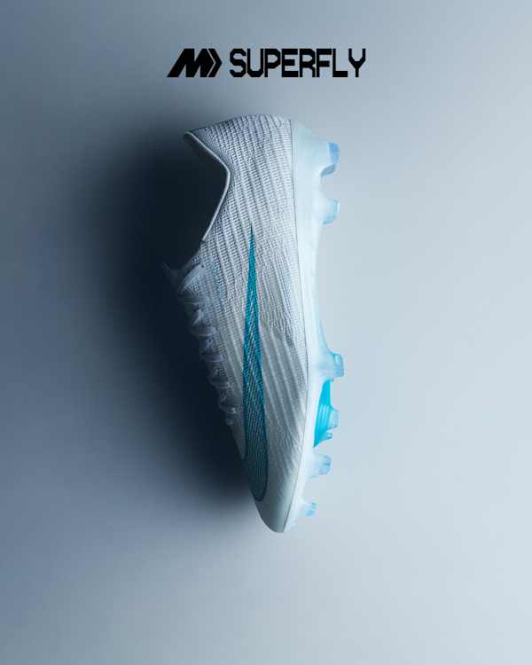 Explore the Bright Lights Pack, A white Mercurial Superfly football boot lying on its side on a grey surface, with a teal swoosh and light blue soleplate., slide 1 of 4