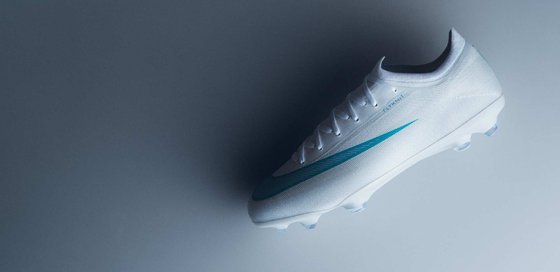 A Jr Vapor football boot lying on a gradient grey background, with a turquoise swoosh and 'FLYKNIT' text., SNABB­HET, PRECI­SION, BOLL­KÄNSLA