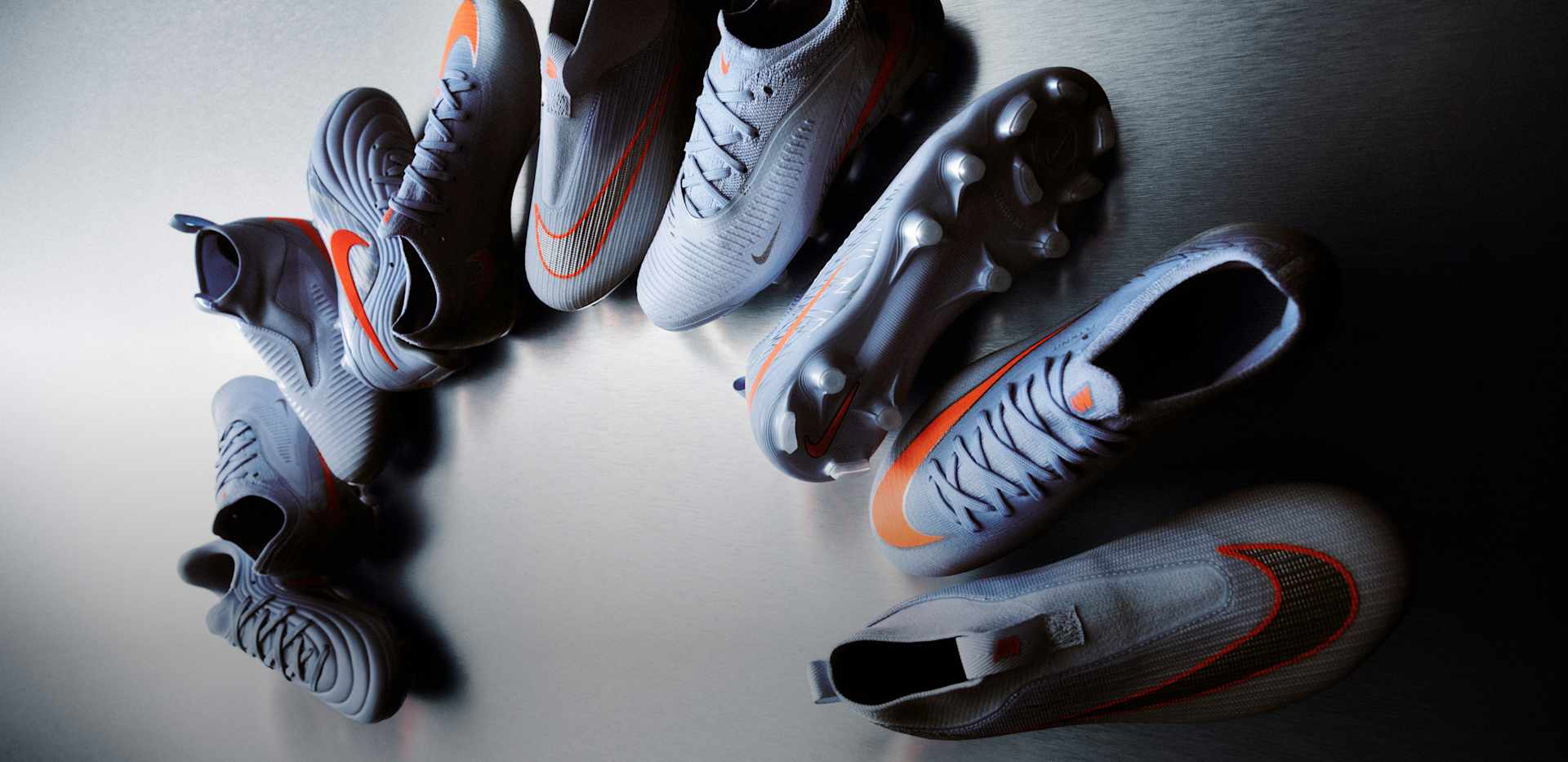 Yeni Nike United ayakkabı serisinin tamamının yukarıdan aşağıya doğru kavisli bir şekilde, mavi ve turuncu renk gruplarıyla birlikte gösterimi., NIKE UNITED