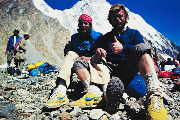 Dağcılar Rick Ridgeway ve John Roskelley'in kayalık bir dağ ana kampında yıpranmış Nike spor ayakkabılarıyla görüldüğü, canlı renkli nostaljik bir fotoğraf., slide 9 of 10