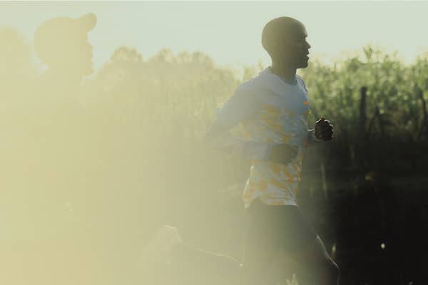 Eliud Kipchoge runs in a sun-drenched outdoor setting., slide 4 of 9