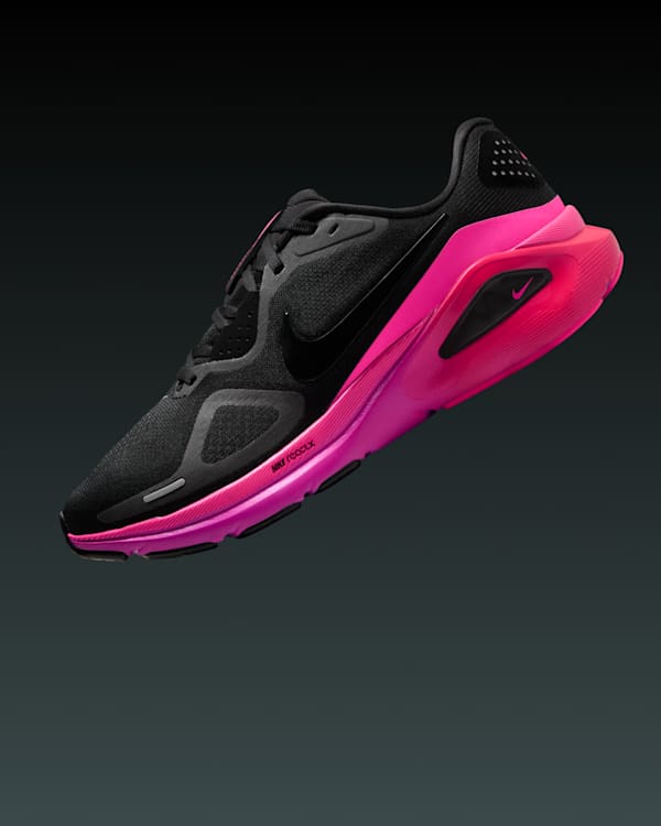A black and pink Nike running shoe displaying on a dark background.