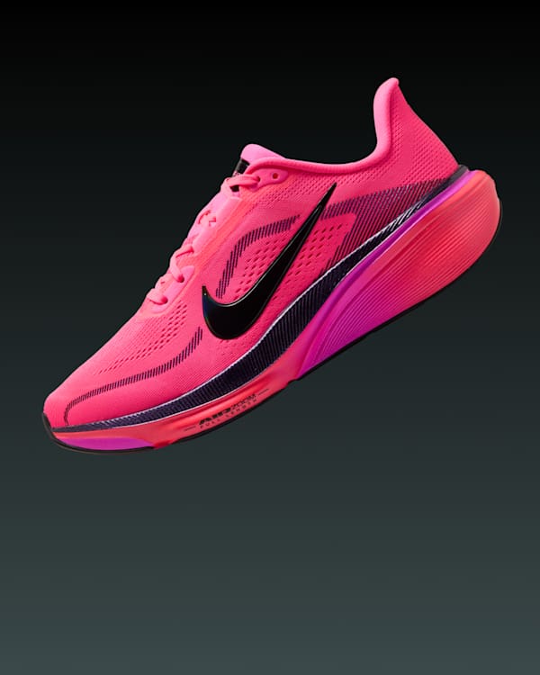 A Nike ZoomX Invincible Run Flyknit 3 in pink with a black swoosh, displayed on a dark background.