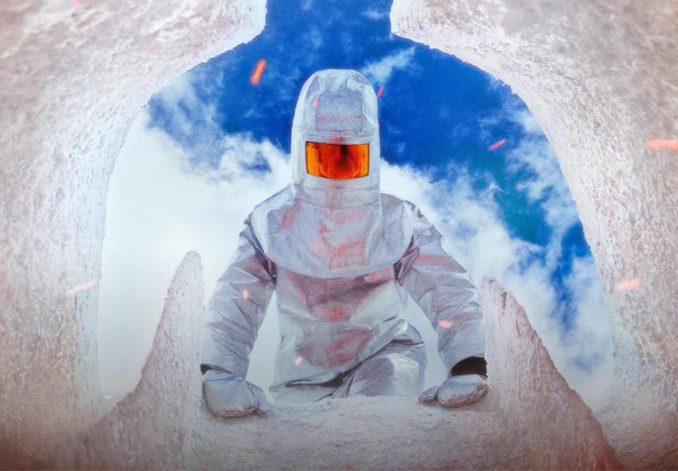 Uma figura veste um fato prateado com integração de design refletor num túnel glacial com um céu azul no alto., Entra no mundo da ACG.