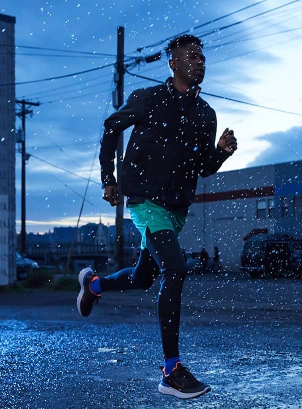 Foto del costado del hombre con ropa deportiva corriendo en invierno