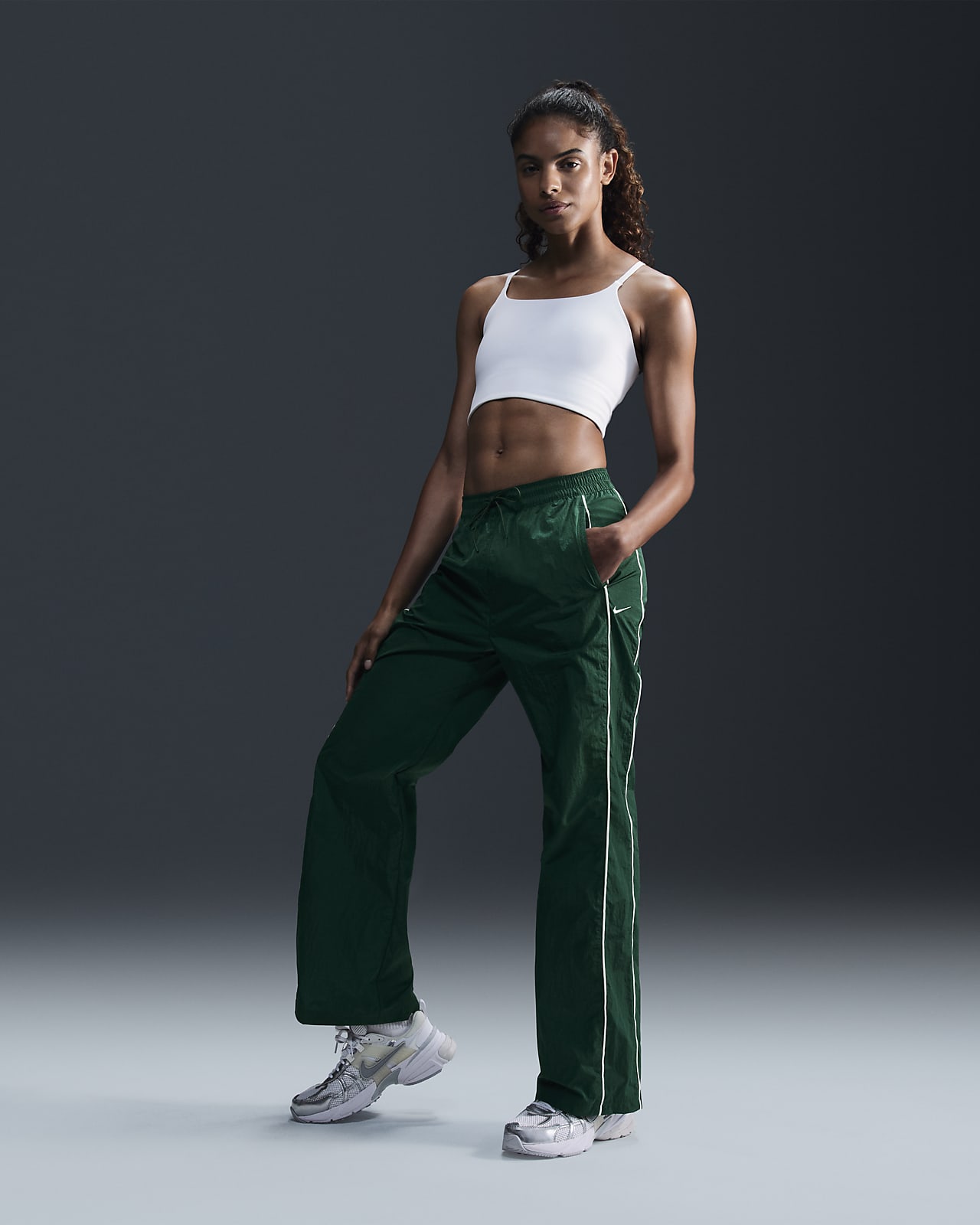 Pantaloni in tessuto a vita alta con bordo aperto Nike Windrunner – Donna
