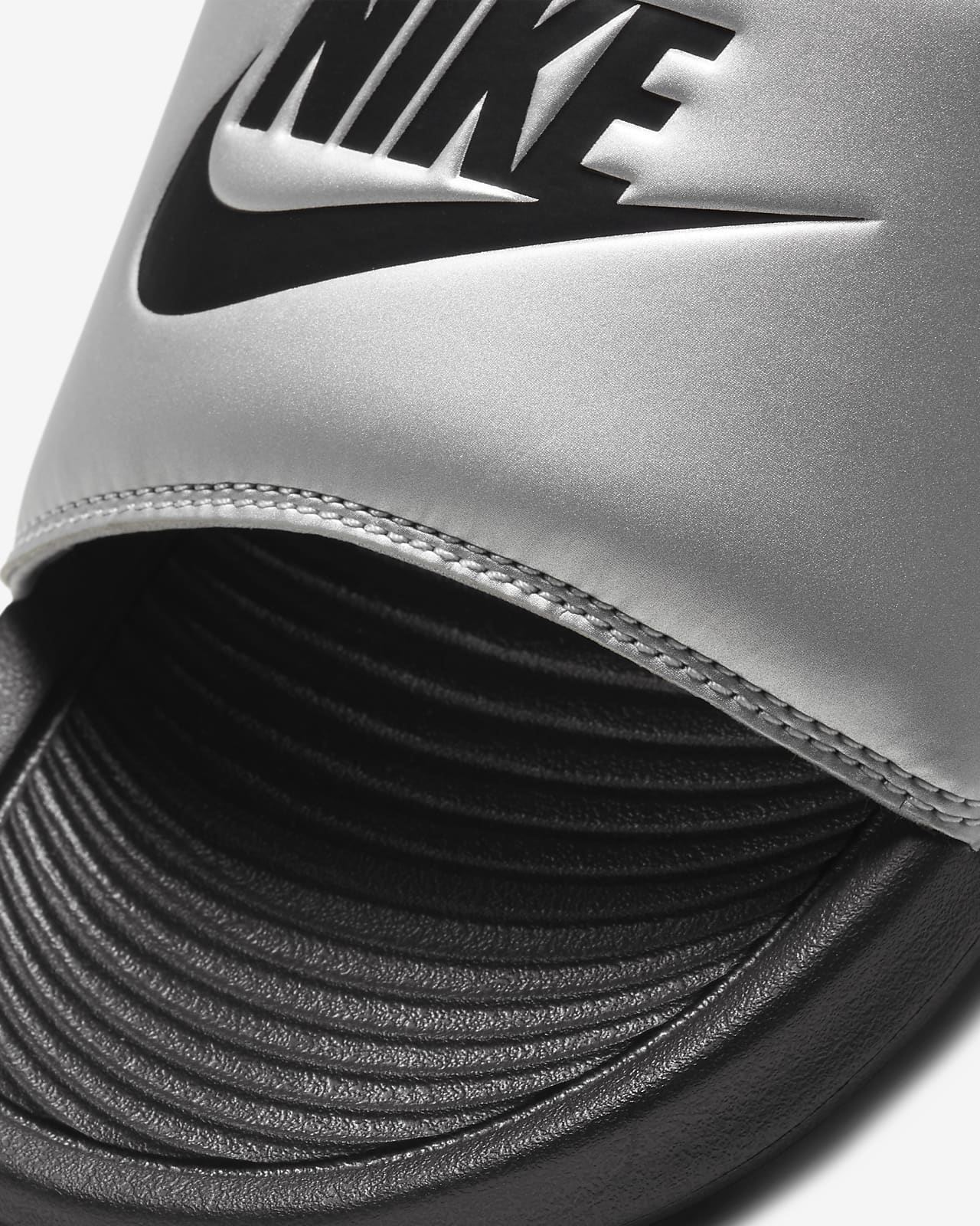 white and silver nike slides
