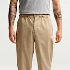 Vävda byxor Nike Club i avsmalnande modell för män