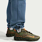 Pants de tejido Fleece con detalles de diseño reflejante con dobladillo abierto para hombre Nike Tech