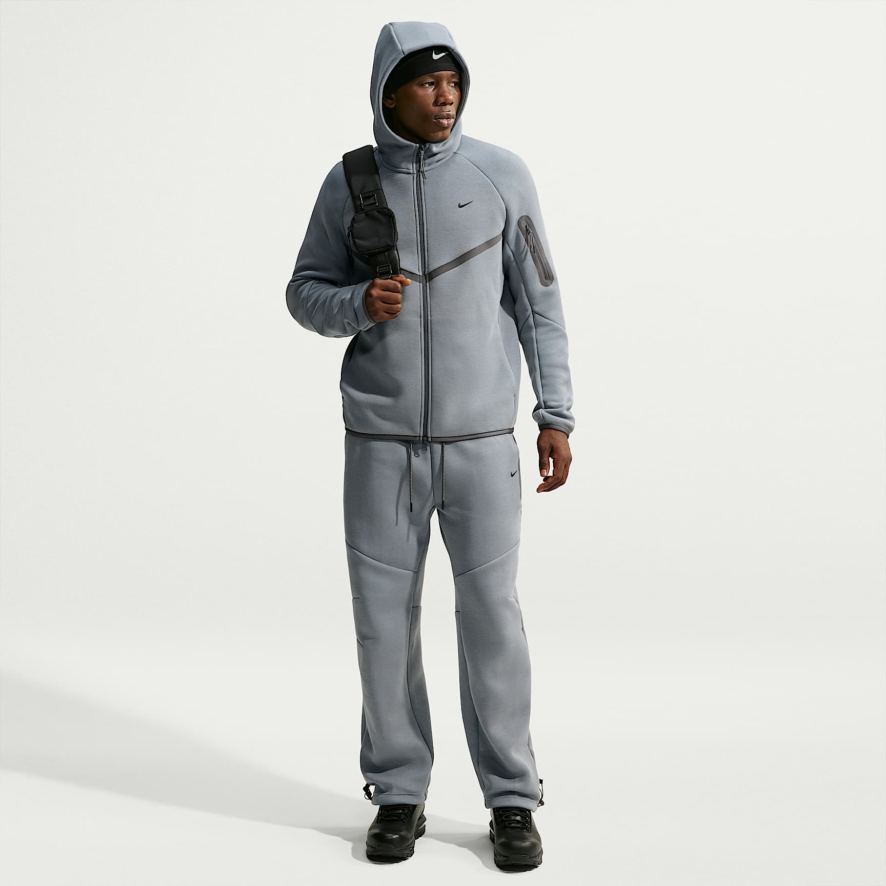 Pants de tejido Fleece con detalles de diseño reflejante con dobladillo abierto para hombre Nike Tech