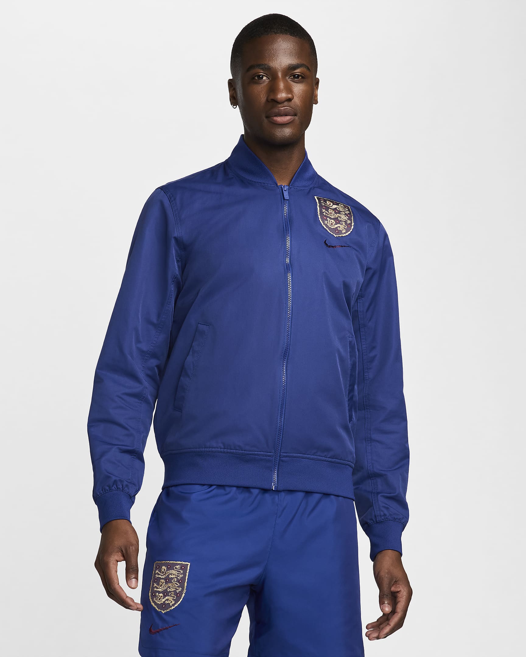 England Sport Essentials Nike Fußball-Bomberjacke aus Webstoff für Herren - Deep Royal Blue/Deep Royal Blue/Sesame/Rosewood