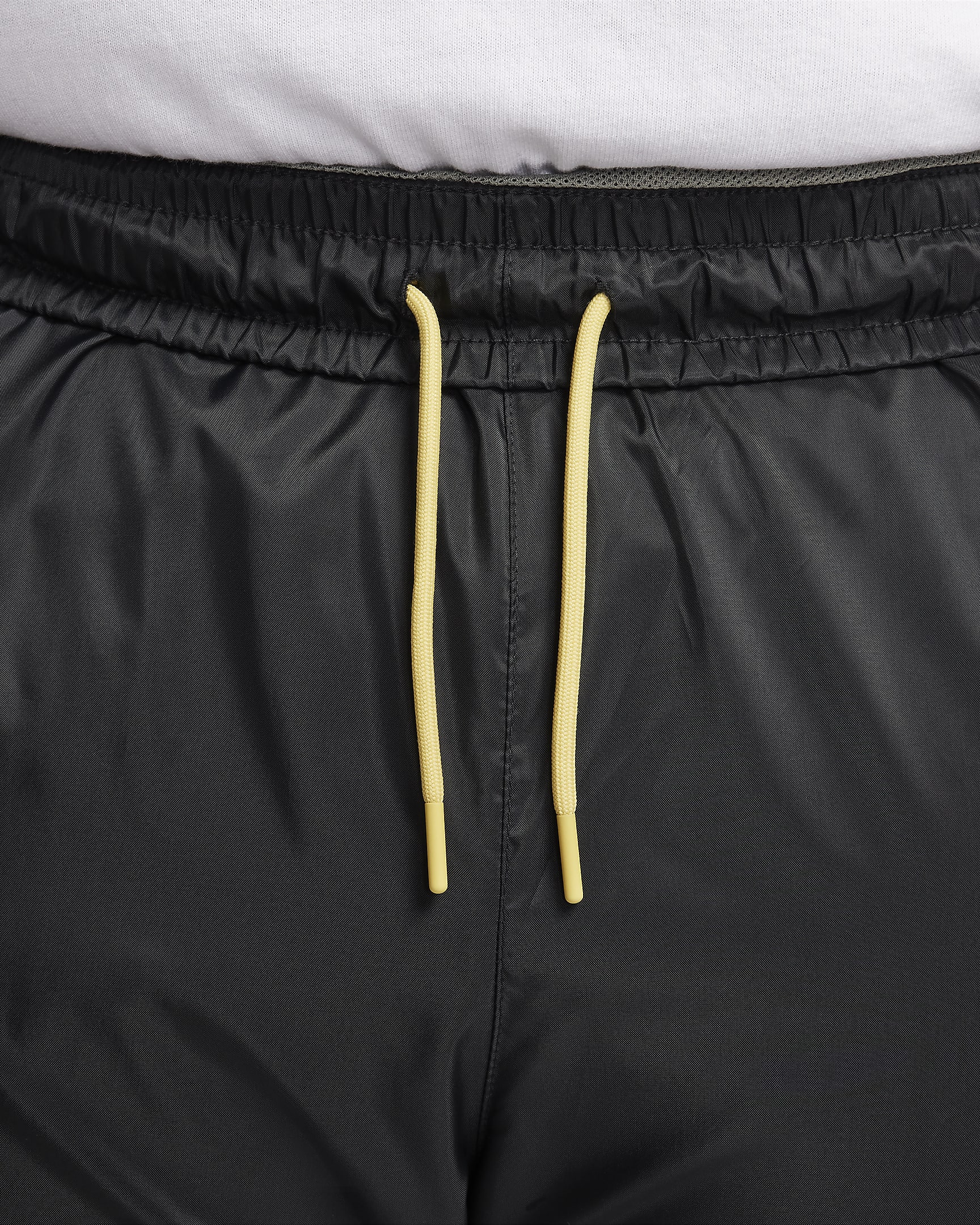 Męskie spodnie z tkaniny z podszewką Nike Windrunner - Czerń/Dark Stucco/Saturn Gold