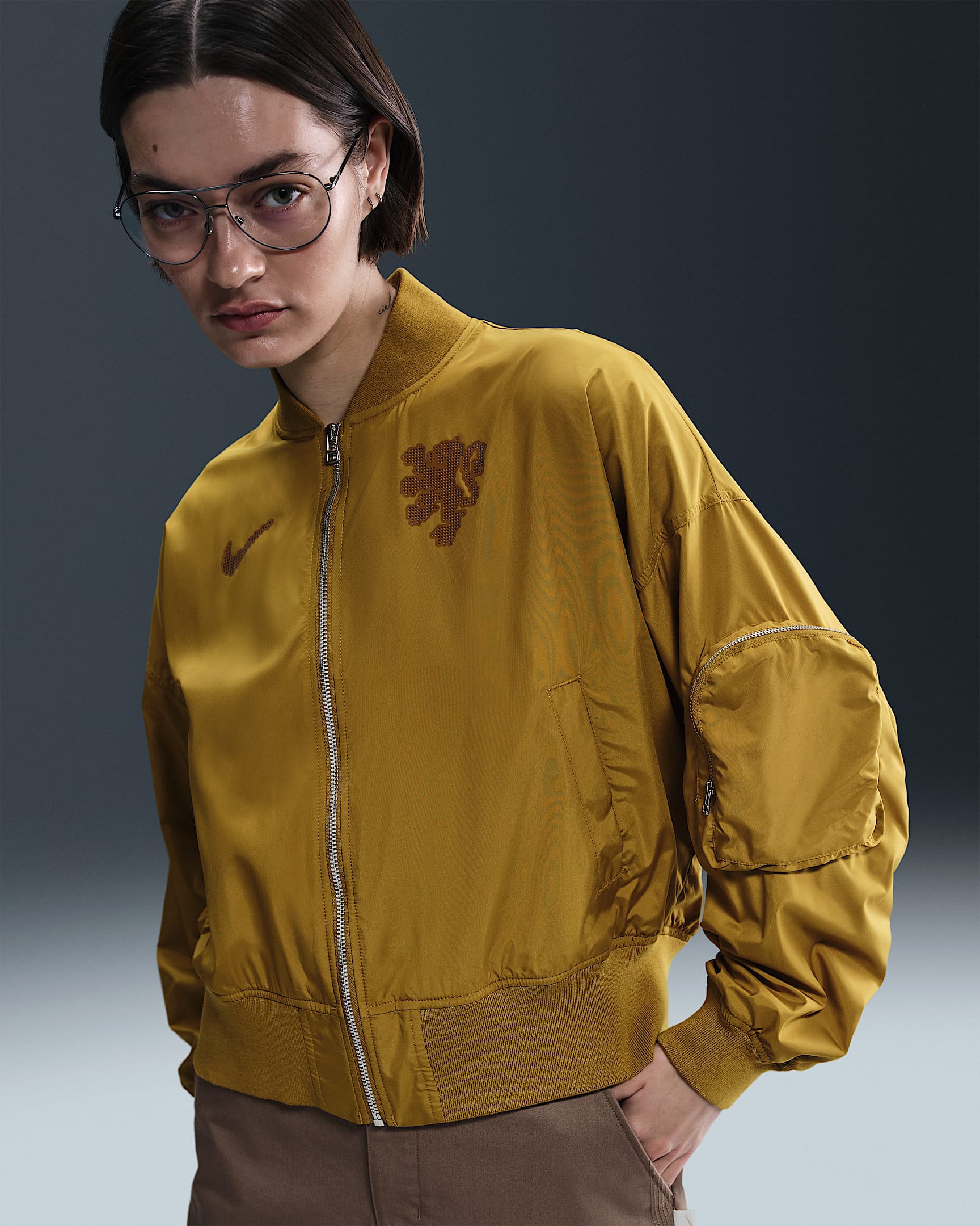 Netherlands Essential Women's Nike Football Oversized Bomber - Bronzine/Safety Orange/Black