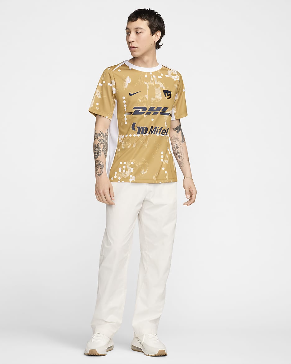 Playera de fútbol de manga corta Nike Dri-FIT para antes del partido para hombre Pumas UNAM Academy Pro - Oro genuino/Oro genuino/Blanco/Obsidiana