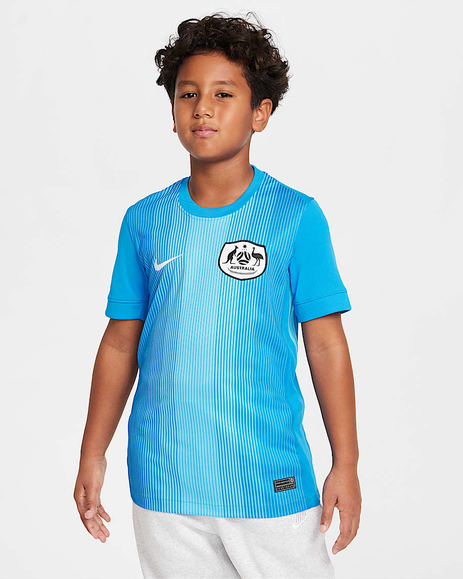 Replika brankářského fotbalového dresu Nike Dri-FIT Austrálie Stadium 2025/26 pro větší děti s krátkým rukávem - Photo Blue/Baltic Blue/Bílá