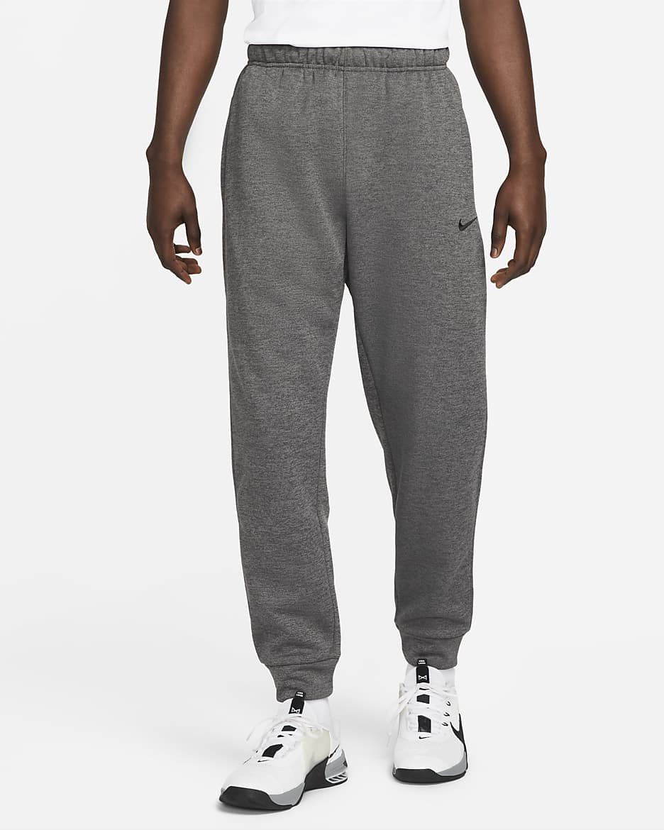 Träningsbyxor Nike Therma-FIT i avsmalnande modell för män - Charcoal Heather/Dark Smoke Grey/Svart