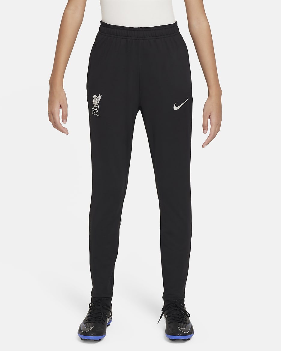 Liverpool FC Strike Pantalón de fútbol de tejido Knit Nike Dri-FIT - Niño/a - Negro/Gym Red/Light Orewood Brown