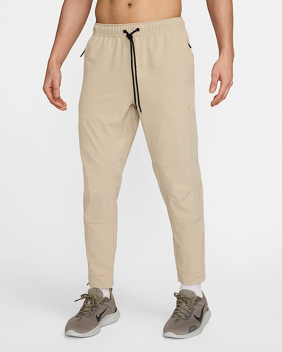 Nike Unlimited Dri-FIT cipzáros szárú, sokoldalú férfinadrág - Desert Khaki/Fekete/Desert Khaki