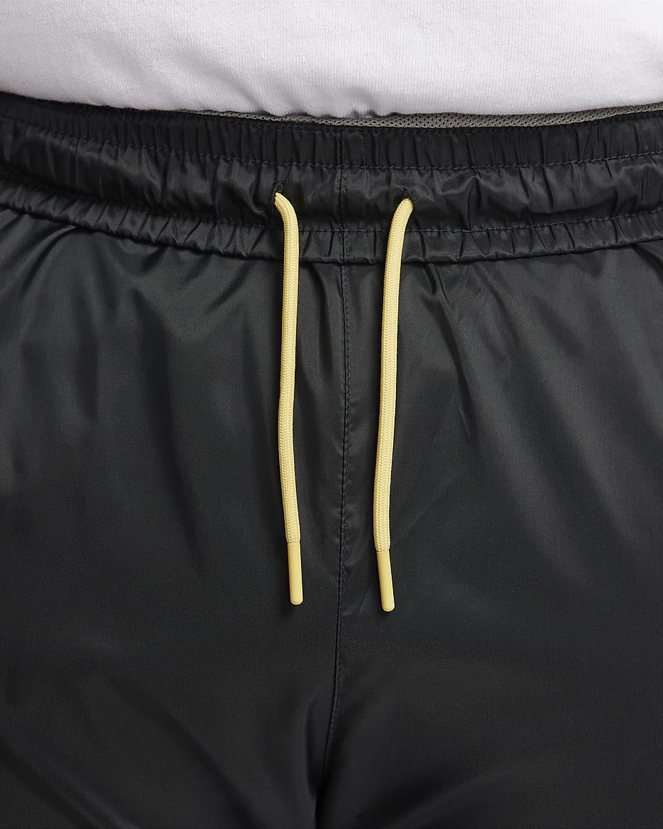 Męskie spodnie z tkaniny z podszewką Nike Windrunner - Czerń/Dark Stucco/Saturn Gold