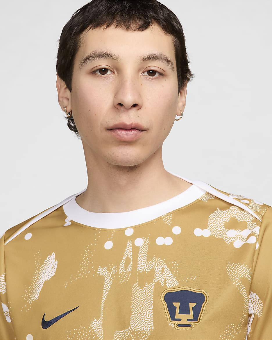 Playera de fútbol de manga corta Nike Dri-FIT para antes del partido para hombre Pumas UNAM Academy Pro - Oro genuino/Oro genuino/Blanco/Obsidiana