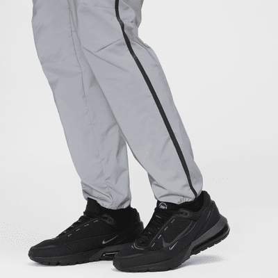 Pantaloni in tessuto con design rifrangente Nike Tech – Uomo