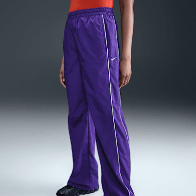 Pantaloni in tessuto a vita alta con bordo aperto Nike Windrunner – Donna