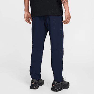 Pantaloni in tessuto con bordo aperto Nike Tech – Uomo