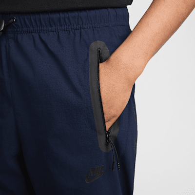 Pantaloni in tessuto con bordo aperto Nike Tech – Uomo