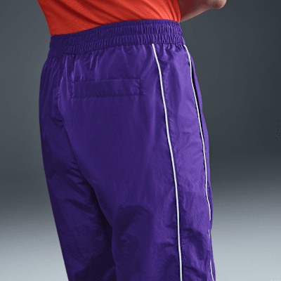 Pantaloni in tessuto a vita alta con bordo aperto Nike Windrunner – Donna