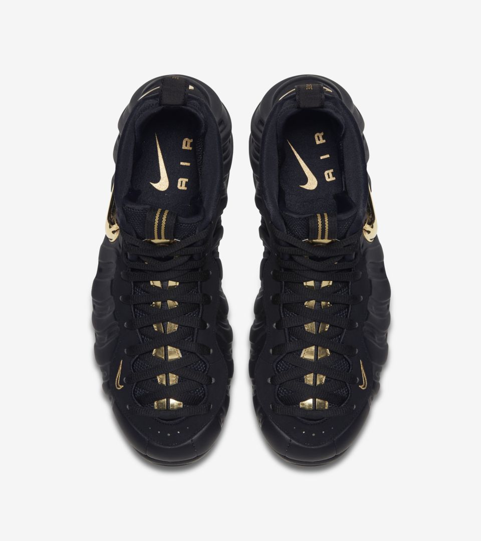 all black foams with gold nike sign