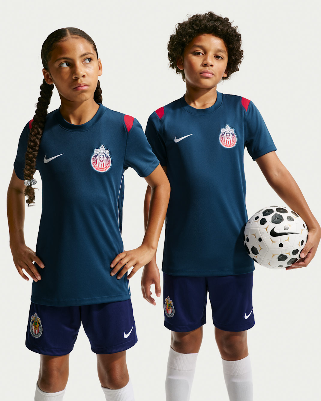 Playera de futbol de manga corta Nike de tejido Knit Dri-FIT para niños talla grande C.D. Guadalajara Academy Pro - Azul valiente/Rojo gimnasio/Blanco