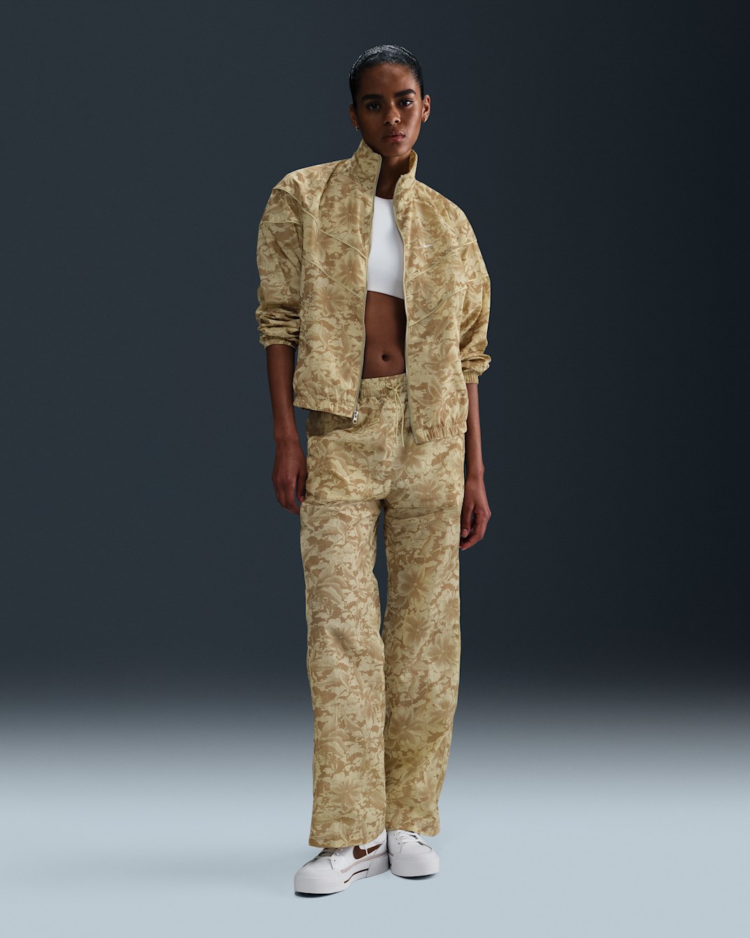 Pants de tejido Woven estampados de tiro medio con protección contra los rayos UV para mujer Nike Sportswear Windrunner - Oro team