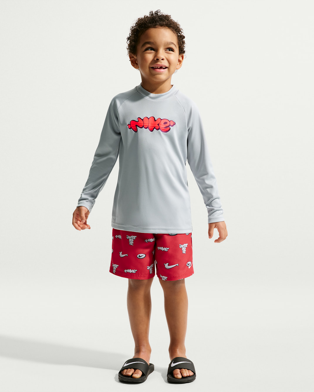 Playera de manga larga Dri-FIT con protección UV para niño talla pequeña Nike Swim Hydroguard Essential - Rojo universitario/Polvo fotón/Rojo universitario/Gris lobo