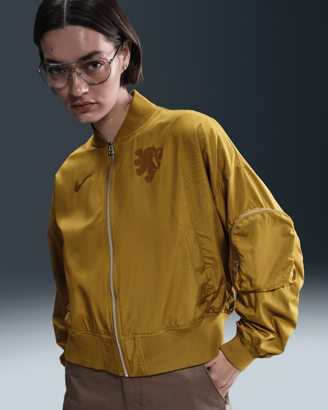 Netherlands Essential Women's Nike Football Oversized Bomber - Bronzine/Safety Orange/Black