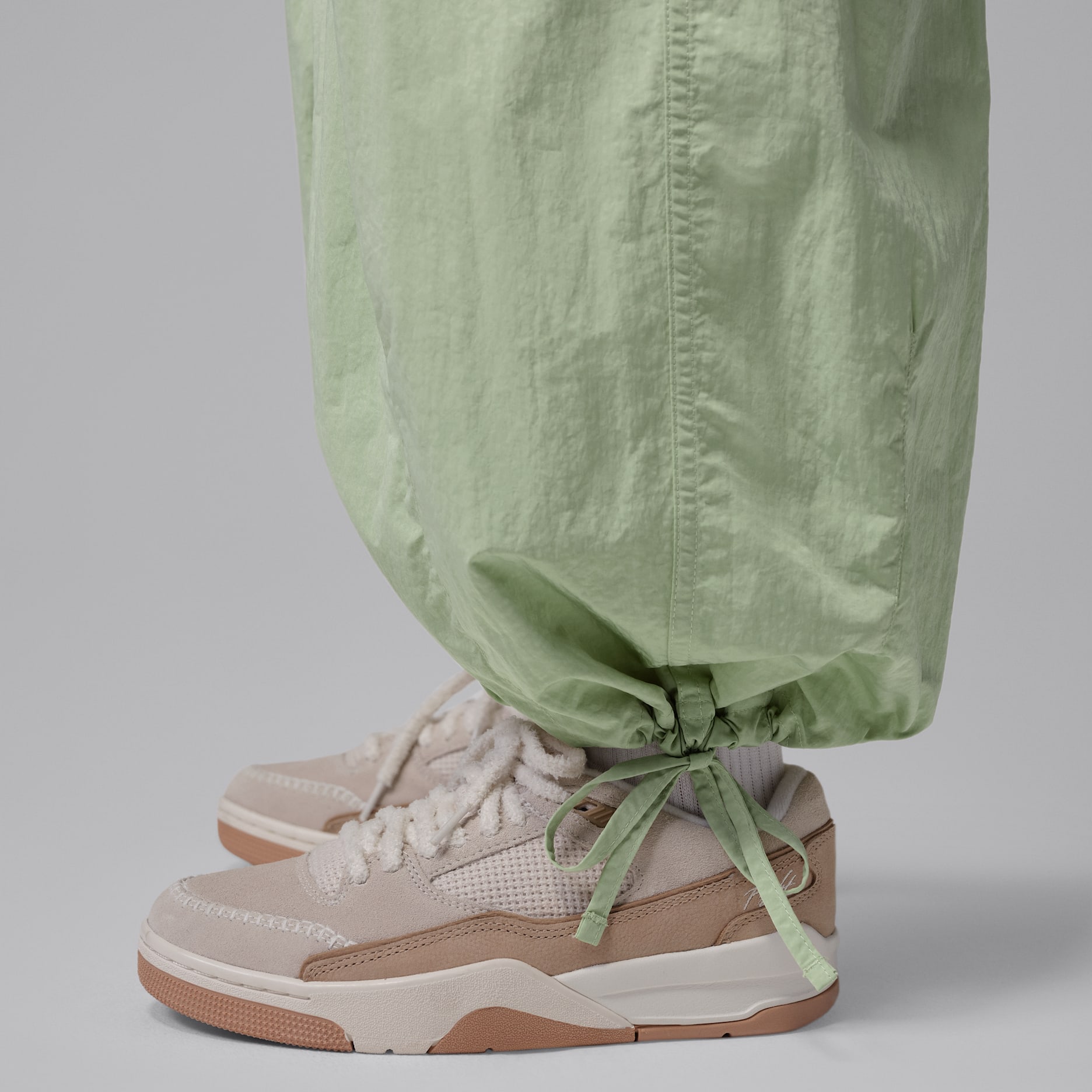 Lightweight nylon gathered around the adjustable drawcord hem of green Jordan Flight Chicago pants