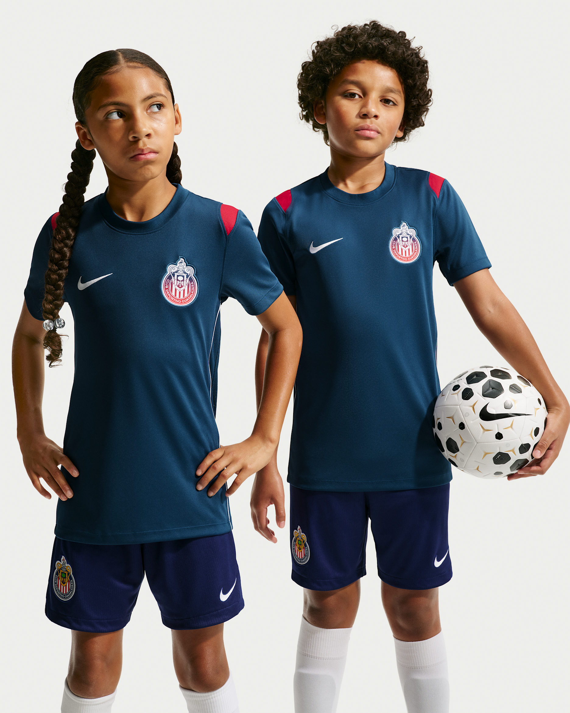 Playera de futbol de manga corta Nike de tejido Knit Dri-FIT para niños talla grande C.D. Guadalajara Academy Pro - Azul valiente/Rojo gimnasio/Blanco