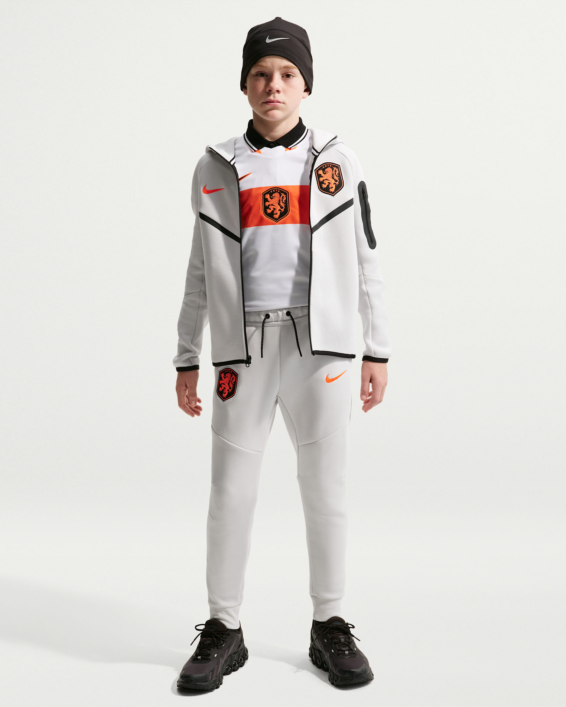 Nederland Tech Fleece Nike voetbalbroek voor jongens - Photon Dust/Photon Dust/Hyper Crimson