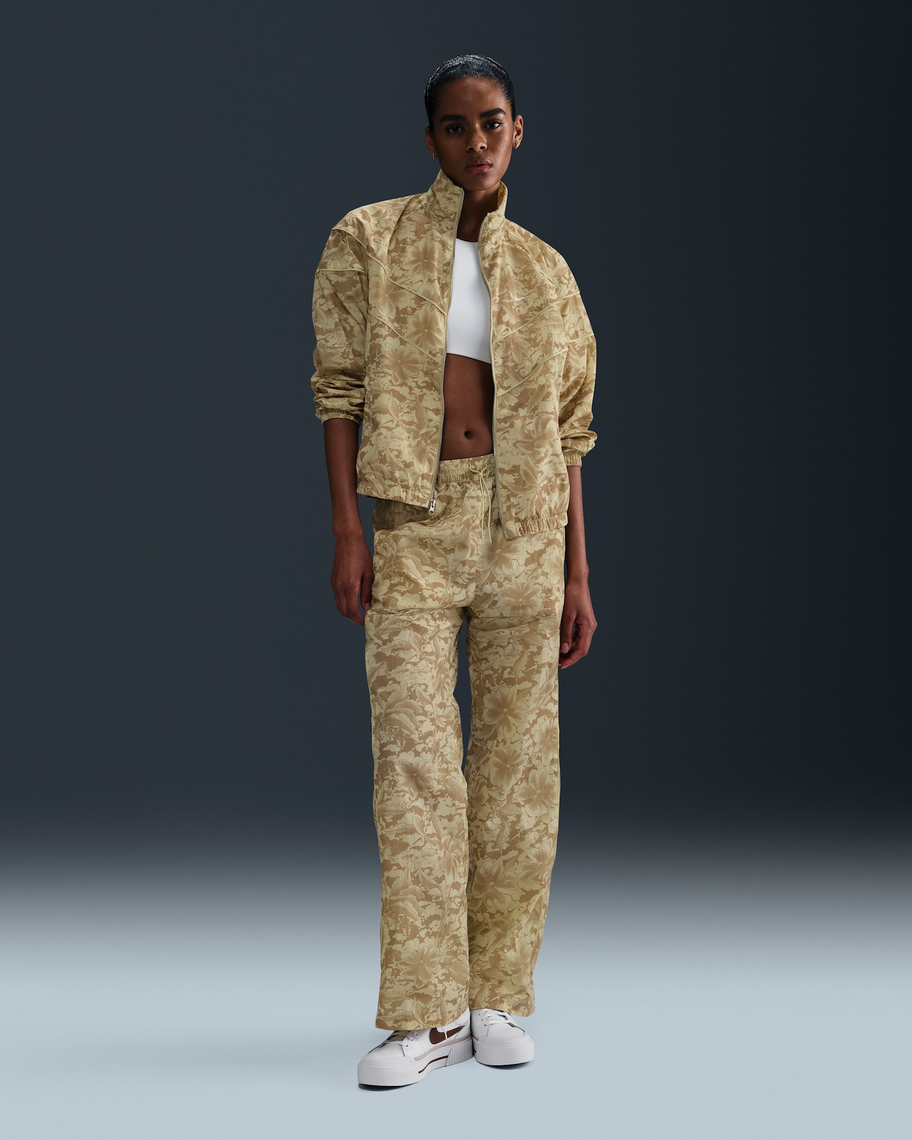 Pants de tejido Woven estampados de tiro medio con protección contra los rayos UV para mujer Nike Sportswear Windrunner - Oro team