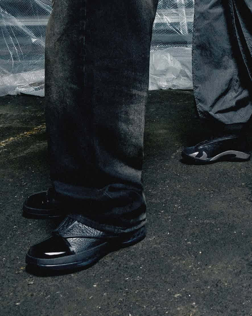 Close-up of photo of black pants falling over black Jordan shoes.