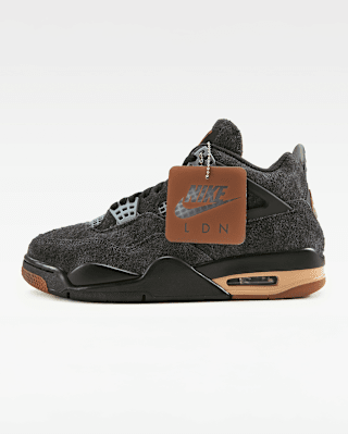 Sobre un fons blanc, es mostra una Jordan 4 de color gris fosc amb detalls gris clar, una sola marró i una etiqueta "Nike LDN".
